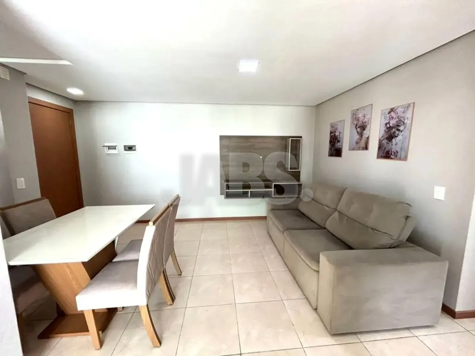 Sala de estar com sofá cinza, painel de TV e mesa de jantar para seis lugares