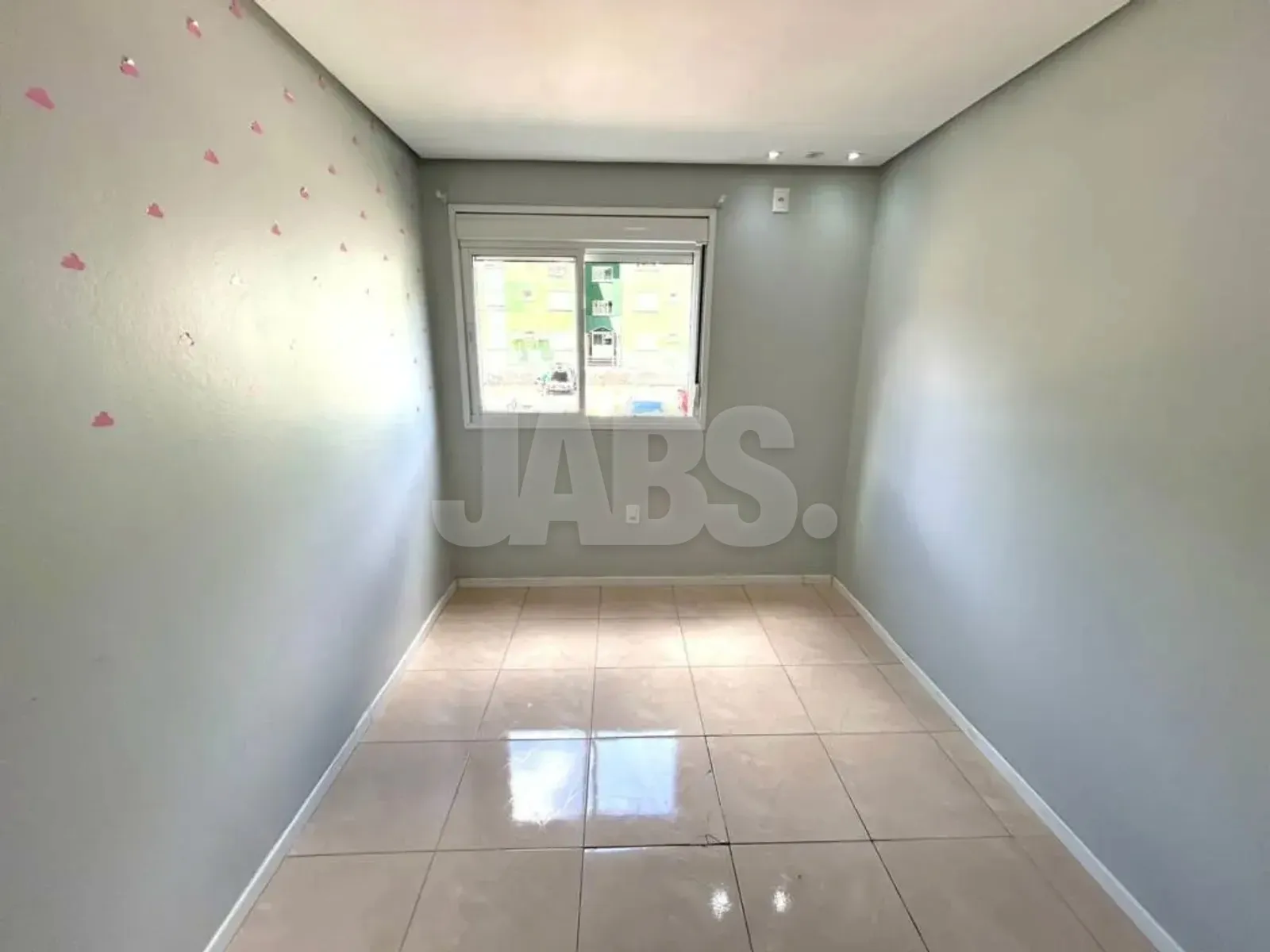 Segundo dormitório com janela e piso cerâmico claro