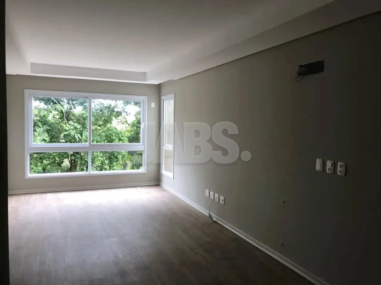 Sala com janela ampla voltada para a mata