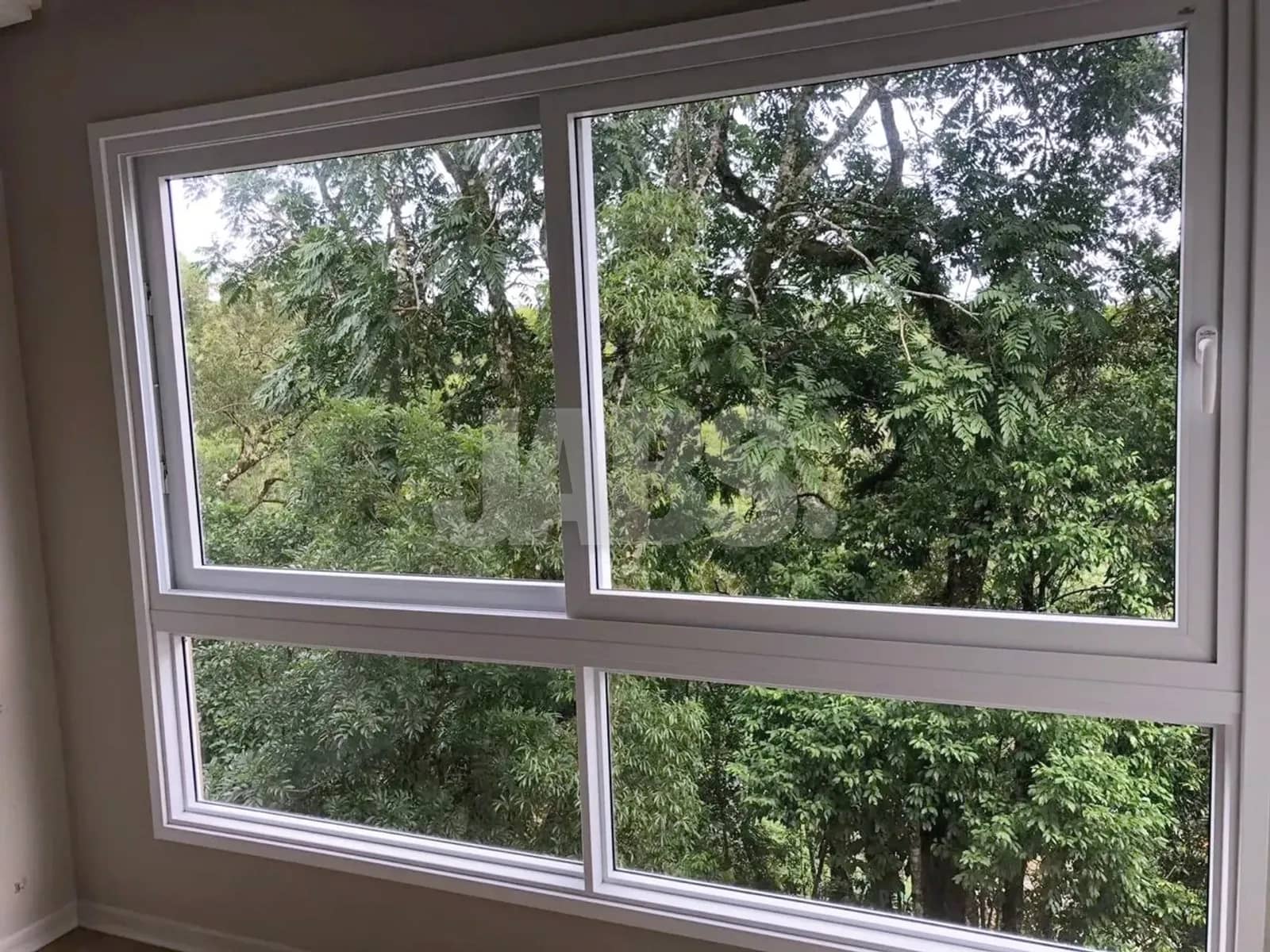 Janela de piso a teto com vista para as árvores