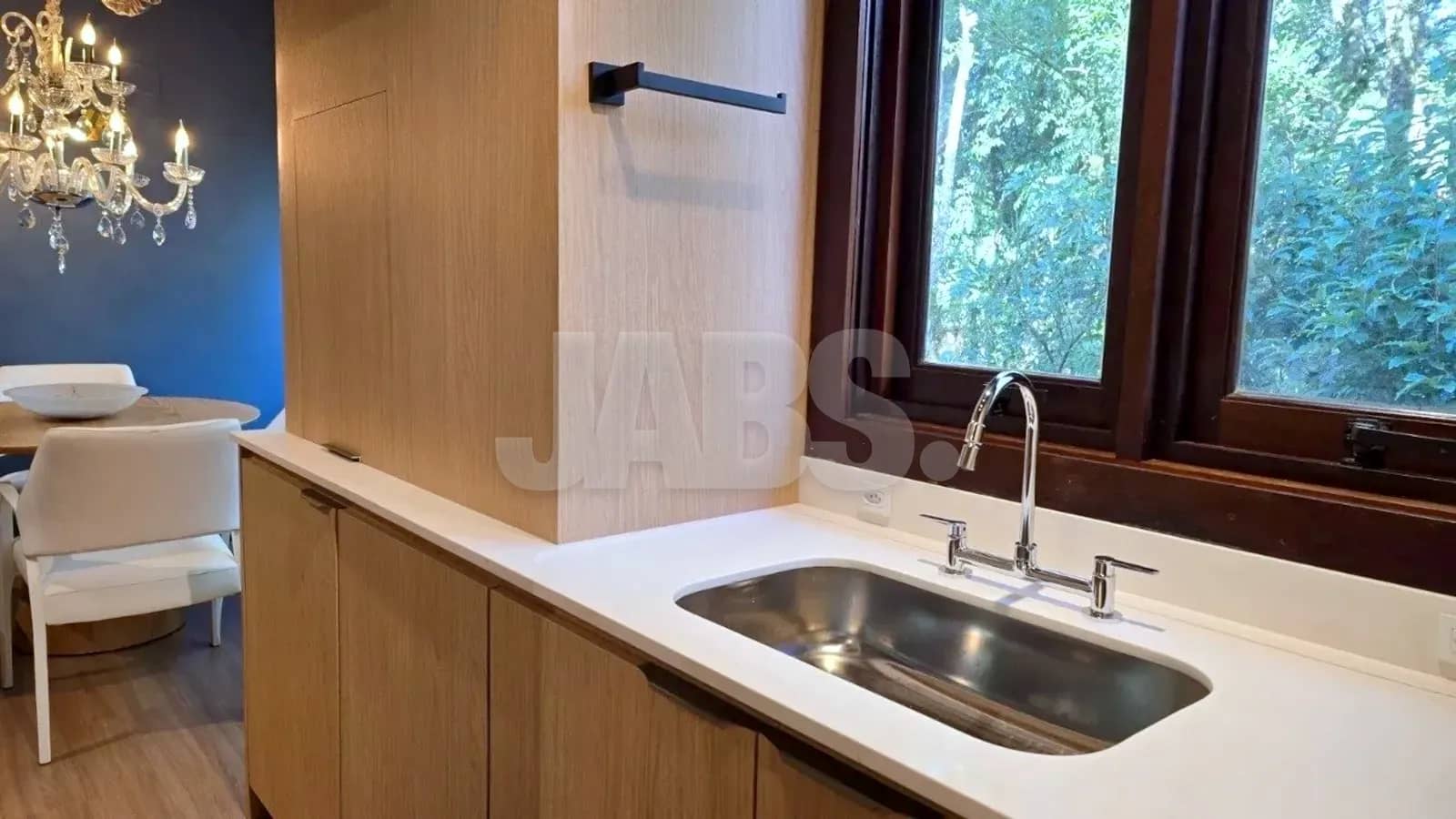 Bancada da cozinha com cuba de inox e janela para o verde