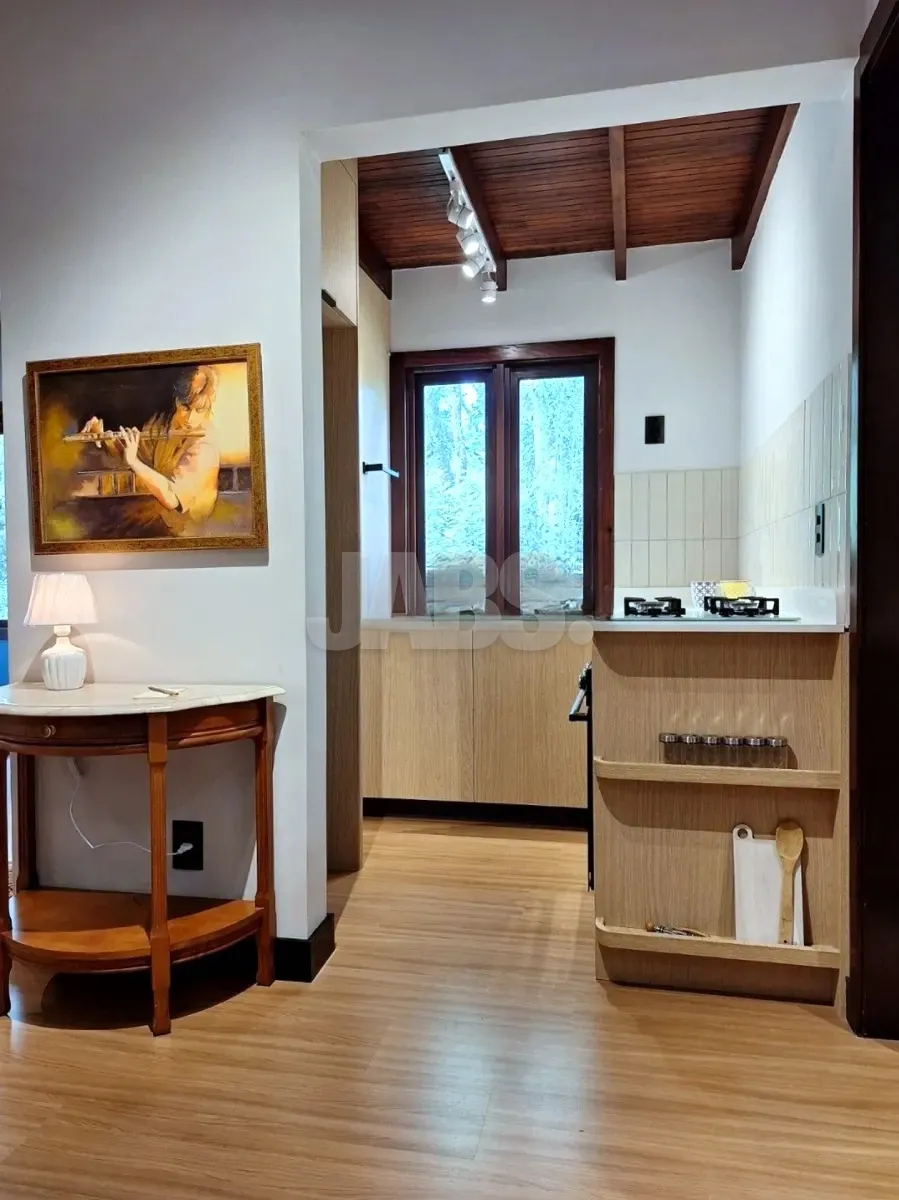 Cozinha com armários claros e janela de madeira