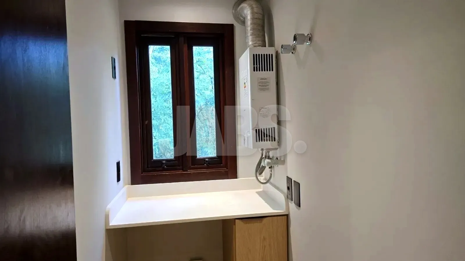Lavanderia com bancada, janela e aquecedor de água