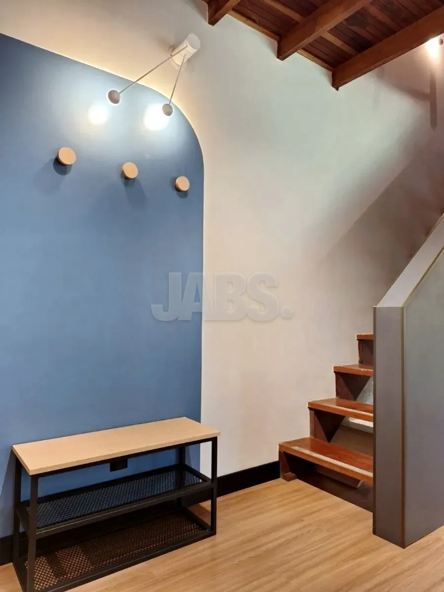 Hall da escada com parede azul, cabideiro e banco de madeira