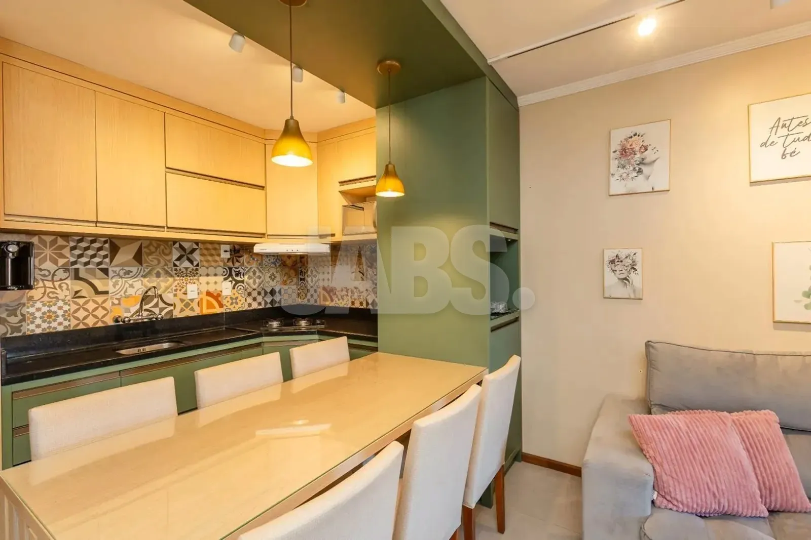 Cozinha americana com armários planejados claros, azulejos decorados e bancada escura