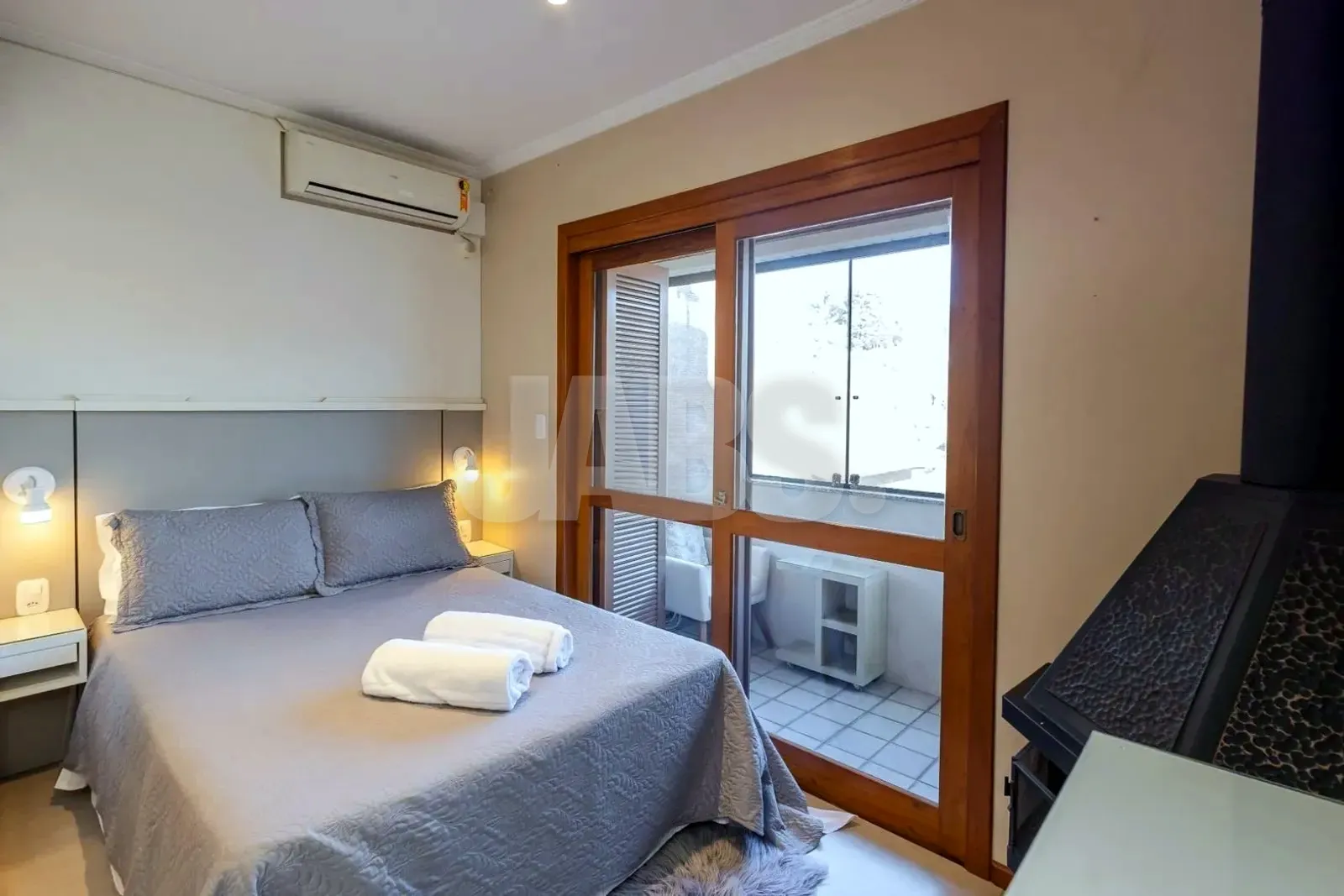 Dormitório com cama de casal e armário com portas espelhadas