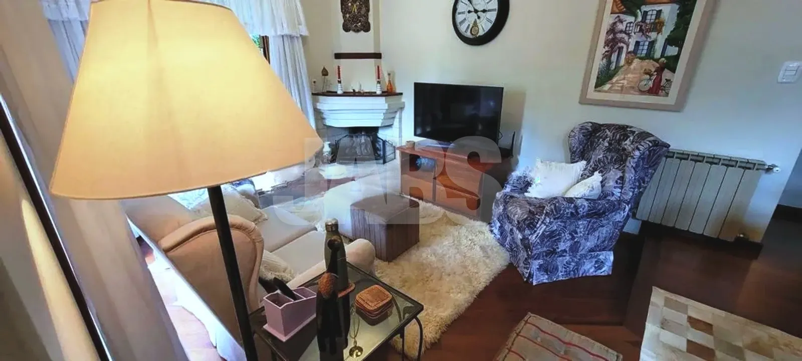 Sala de estar com televisão e poltronas