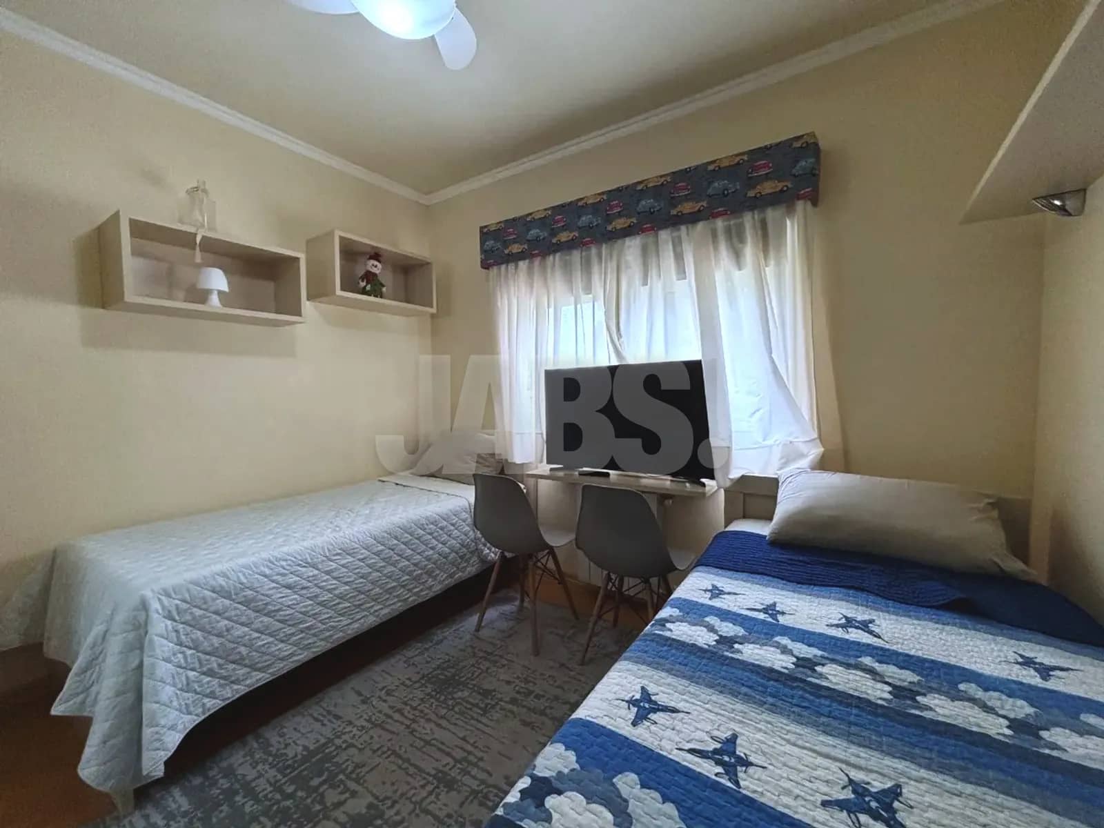 Segundo dormitório com duas camas e TV