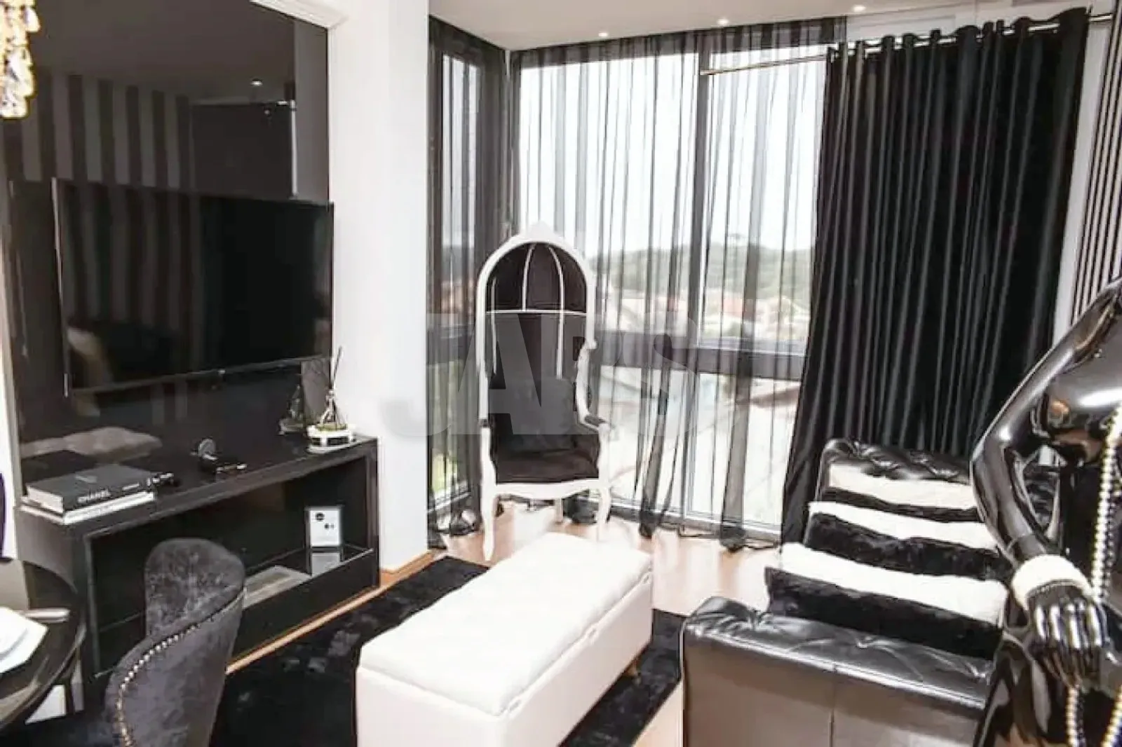 Sala de estar com TV e janelas amplas