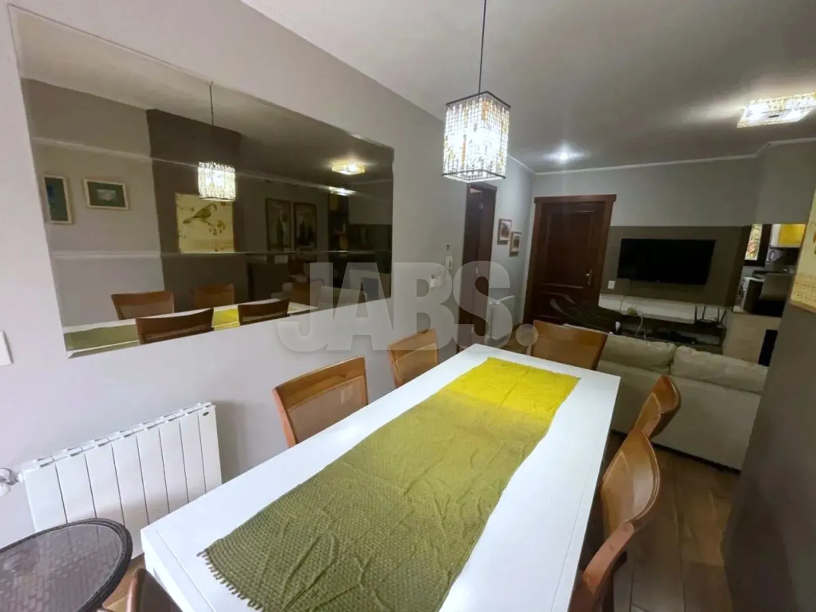 Mesa de jantar para seis com espelho na parede e vista para a sala de estar