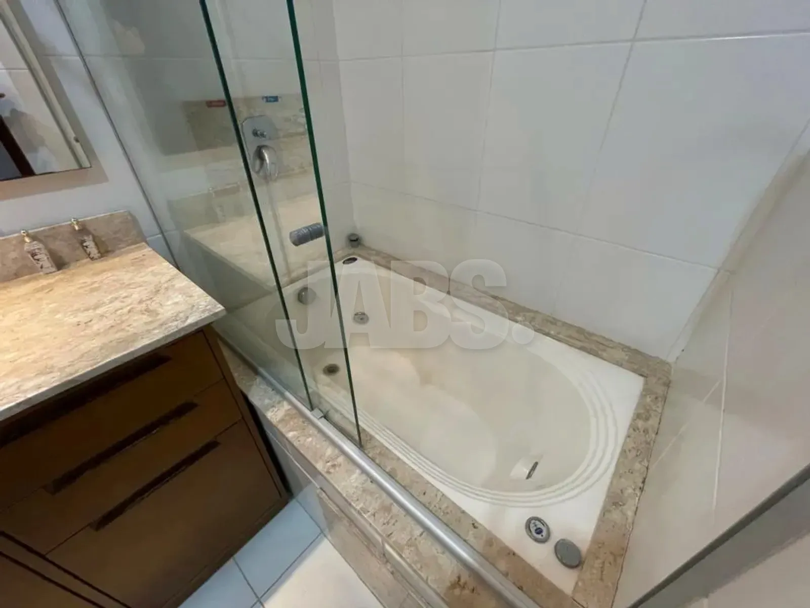 Banheira de hidromassagem com box de vidro no banheiro da suíte