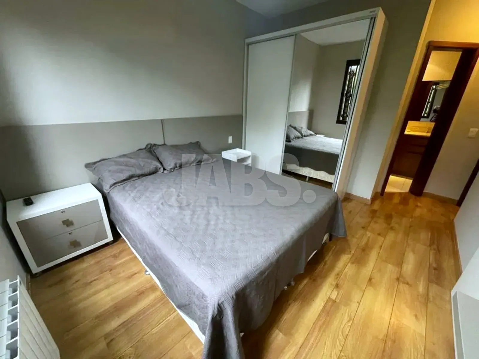 Segundo dormitório com cama de casal e guarda-roupa espelhado