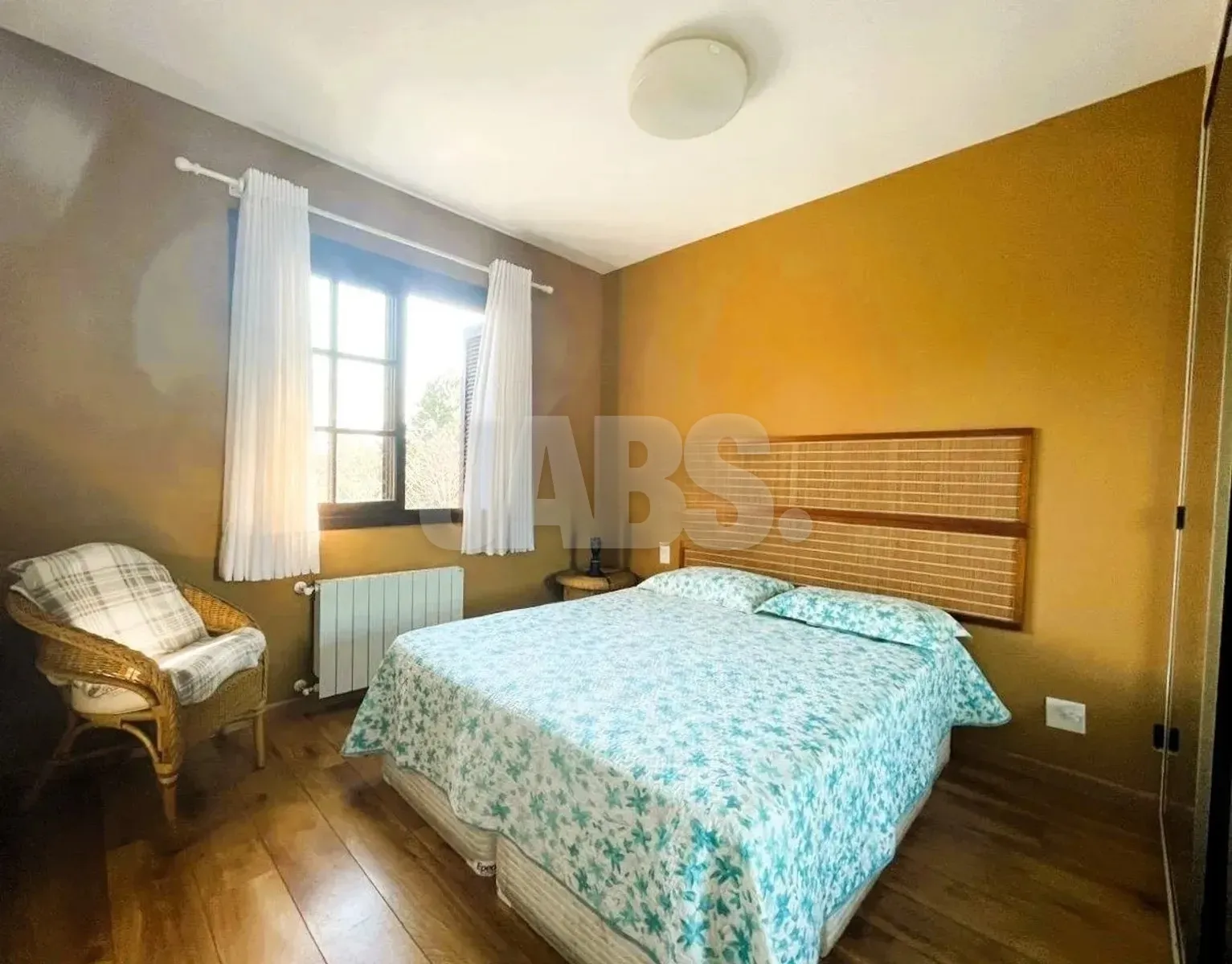 Suíte com cama de casal e cortinas