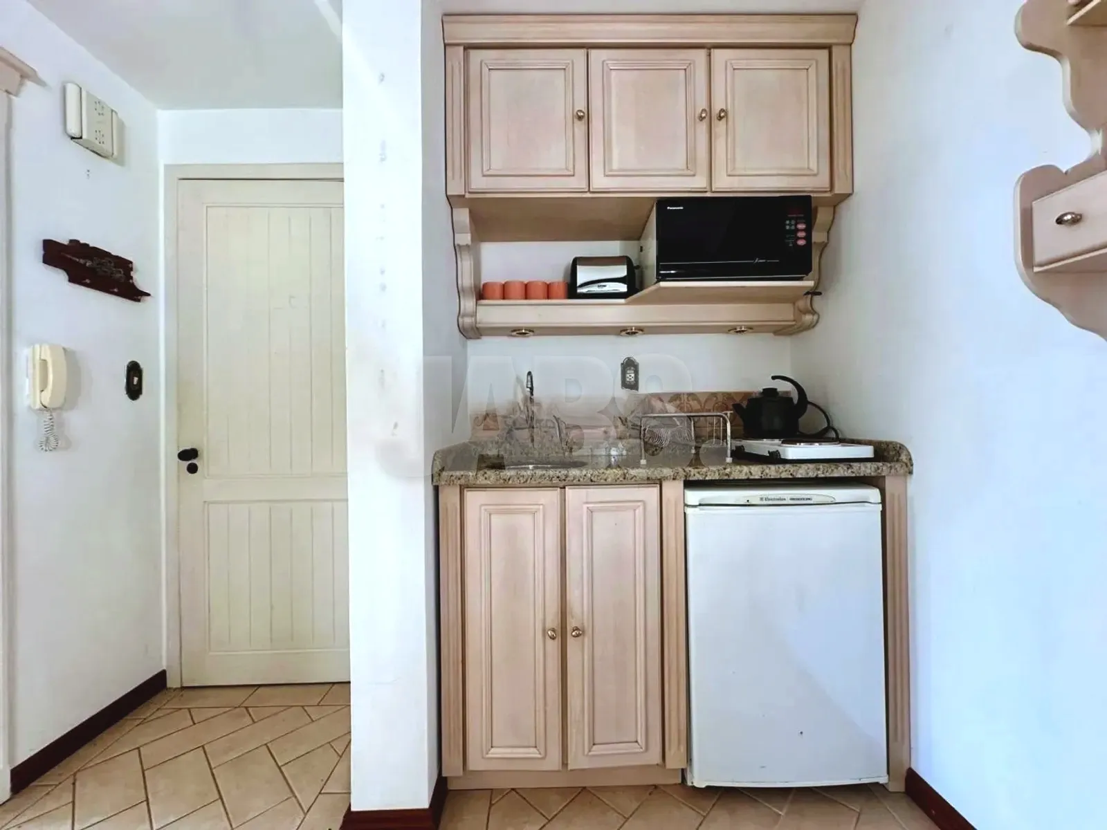 Cozinha com armários e frigobar
