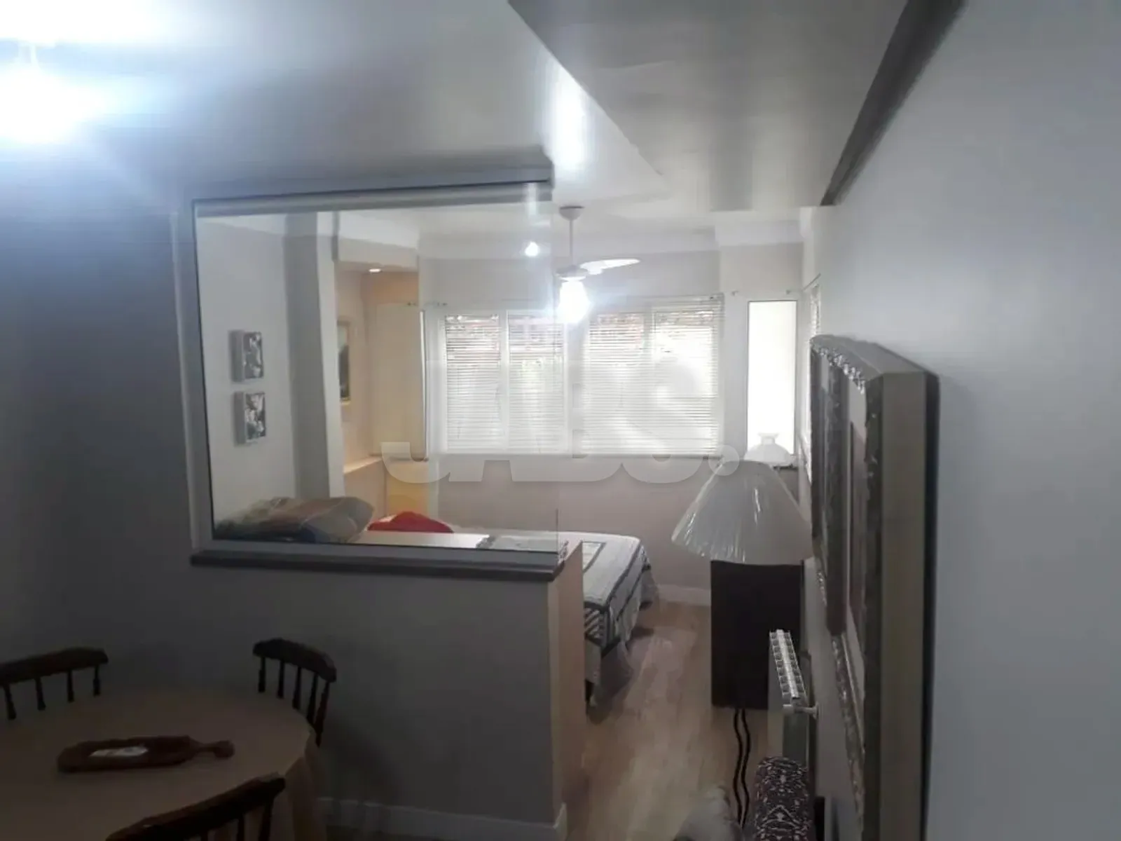 Vista da sala para o recanto da cama, com janelas para o jardim