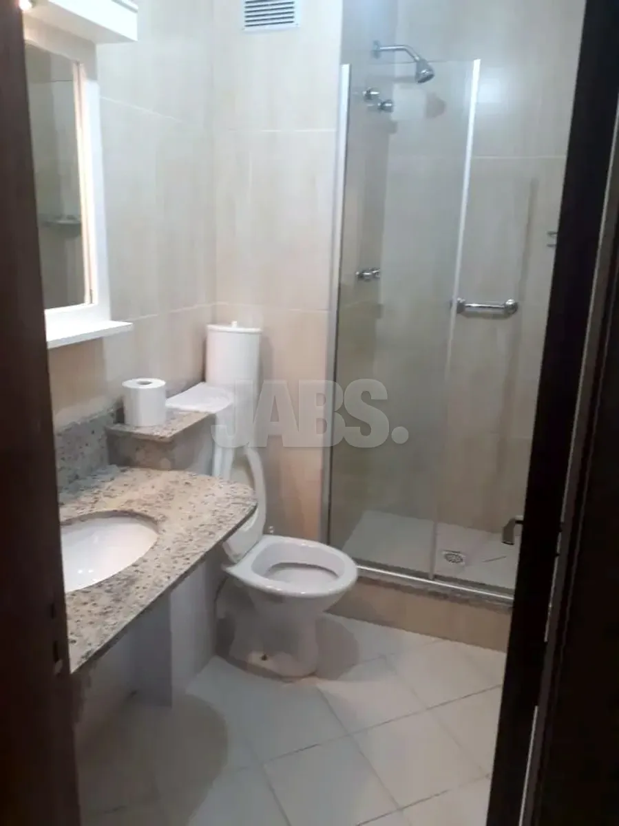 Banheiro com bancada de granito e box de vidro