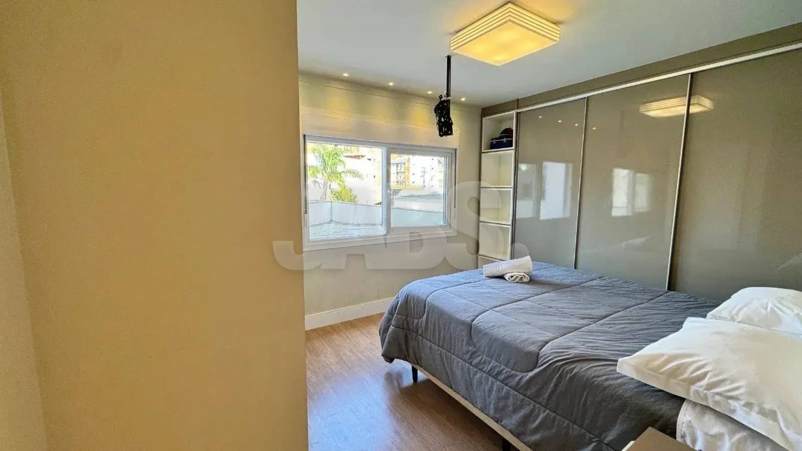 Suíte com cama de casal e armário espelhado