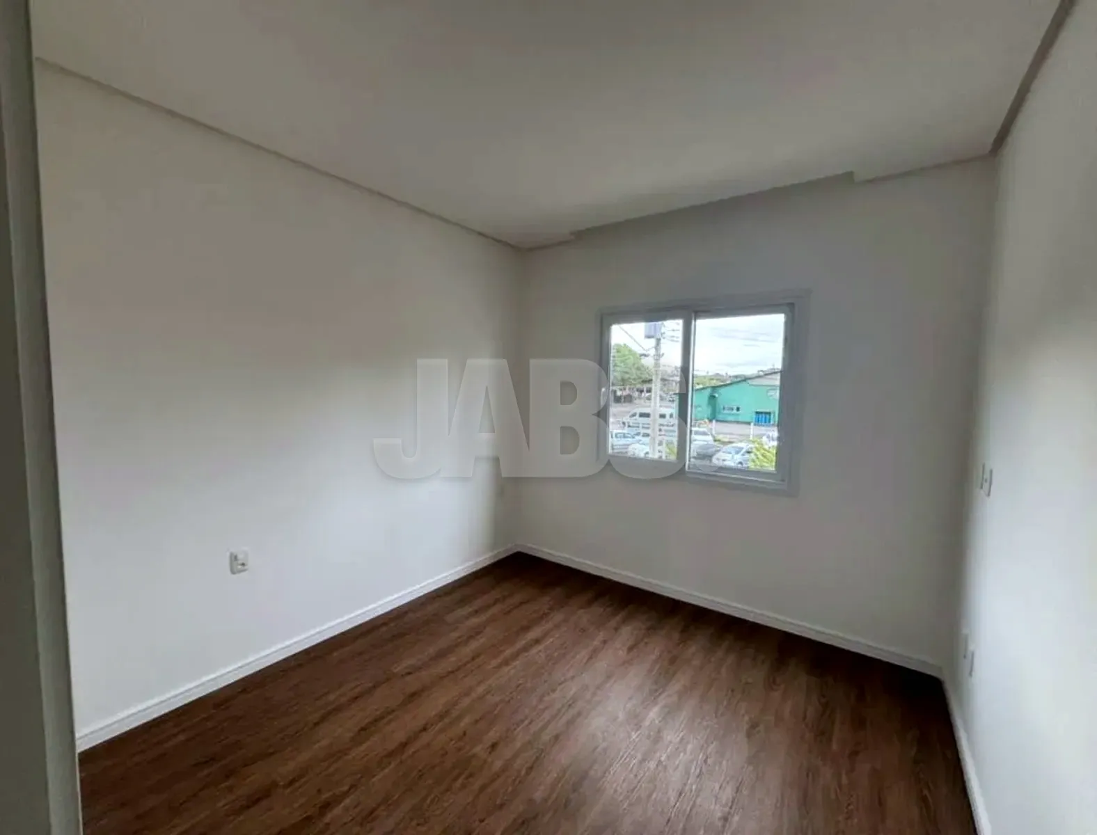 Dormitório com janela ampla e paredes brancas
