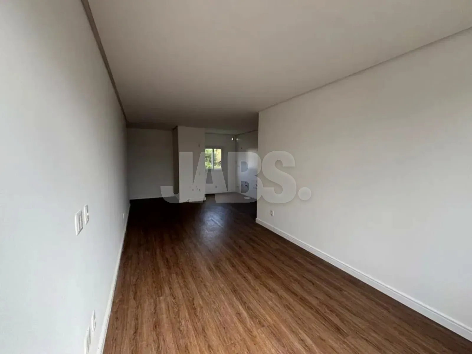 Vista da sala até a área da cozinha, com piso vinílico contínuo