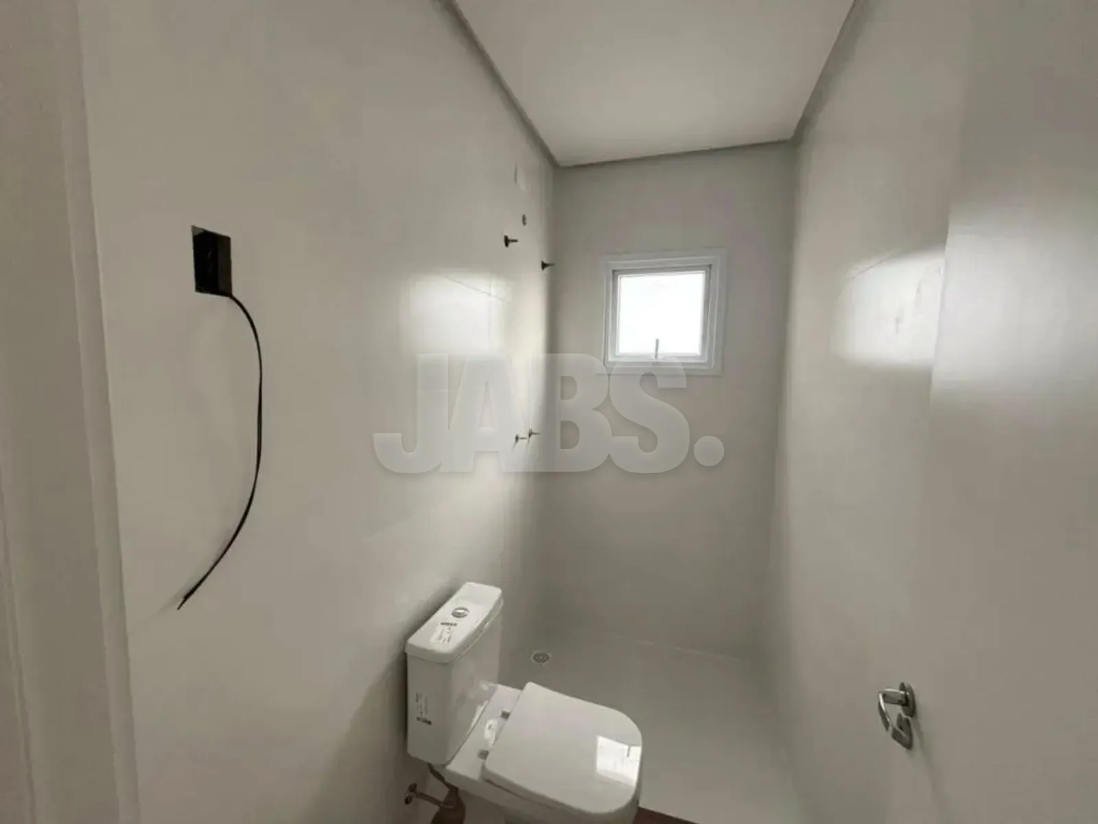 Banheiro com vaso sanitário, janela e pontos para a bancada