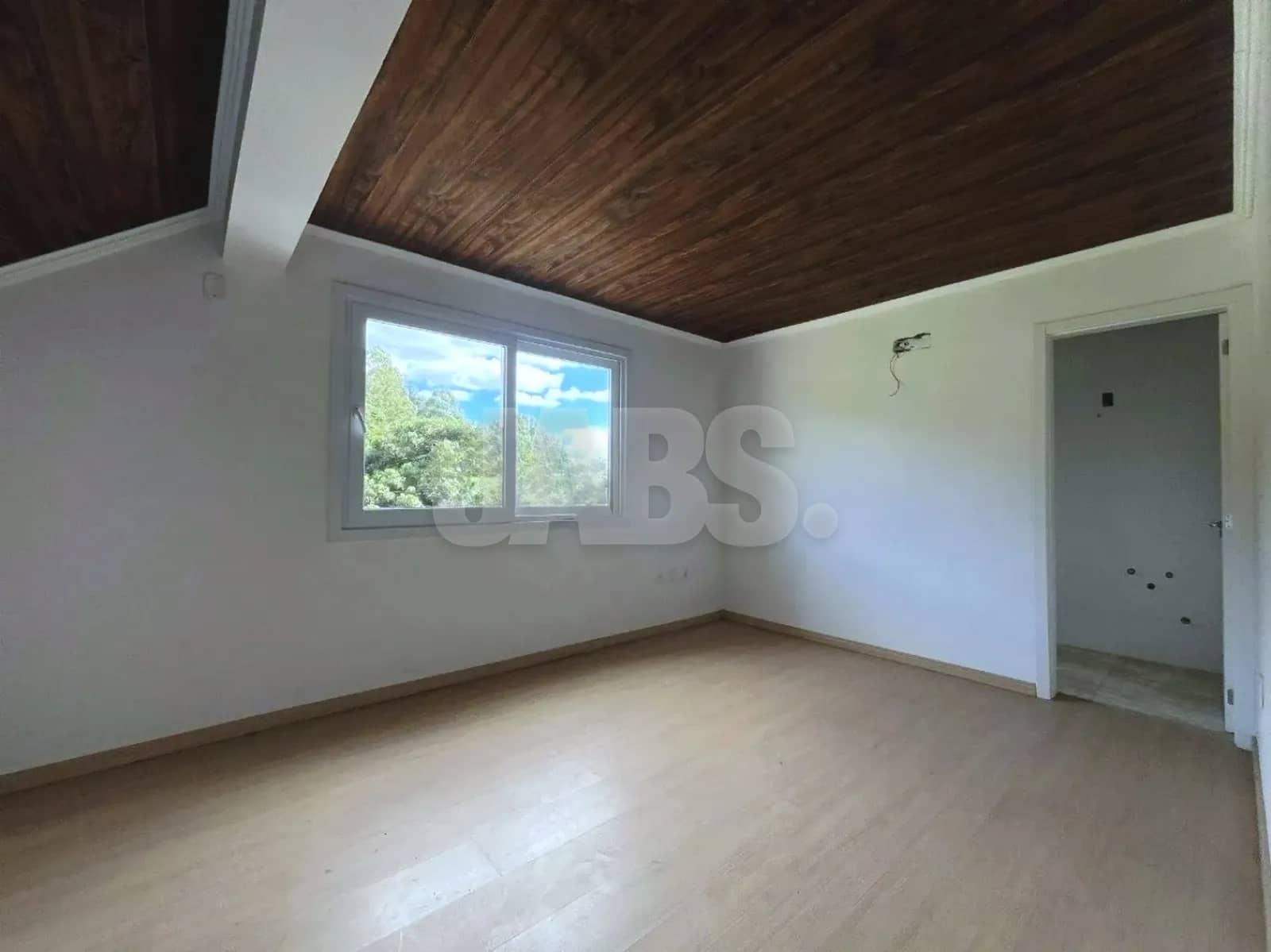 Ambiente com forro de madeira e janela