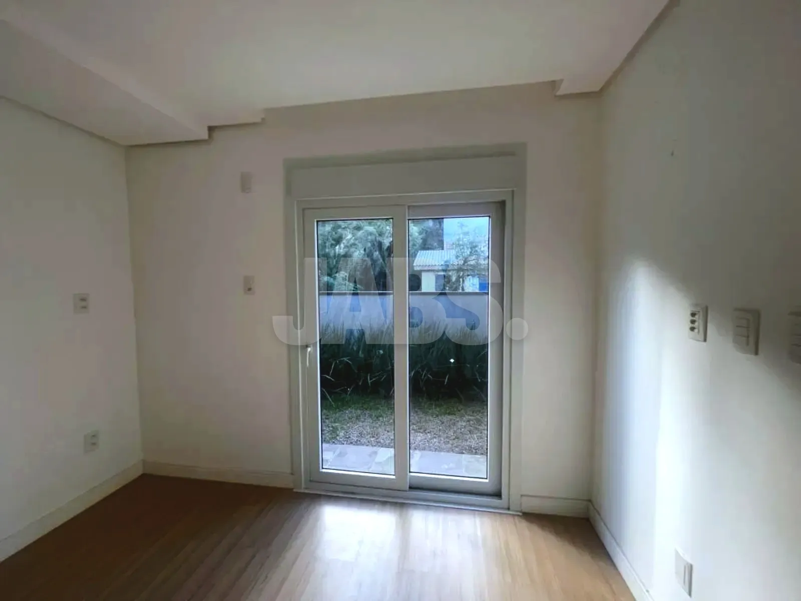 Dormitório com porta de vidro para o pátio