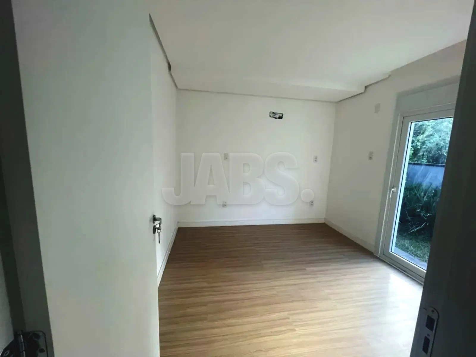 Suíte com piso laminado e janela ampla