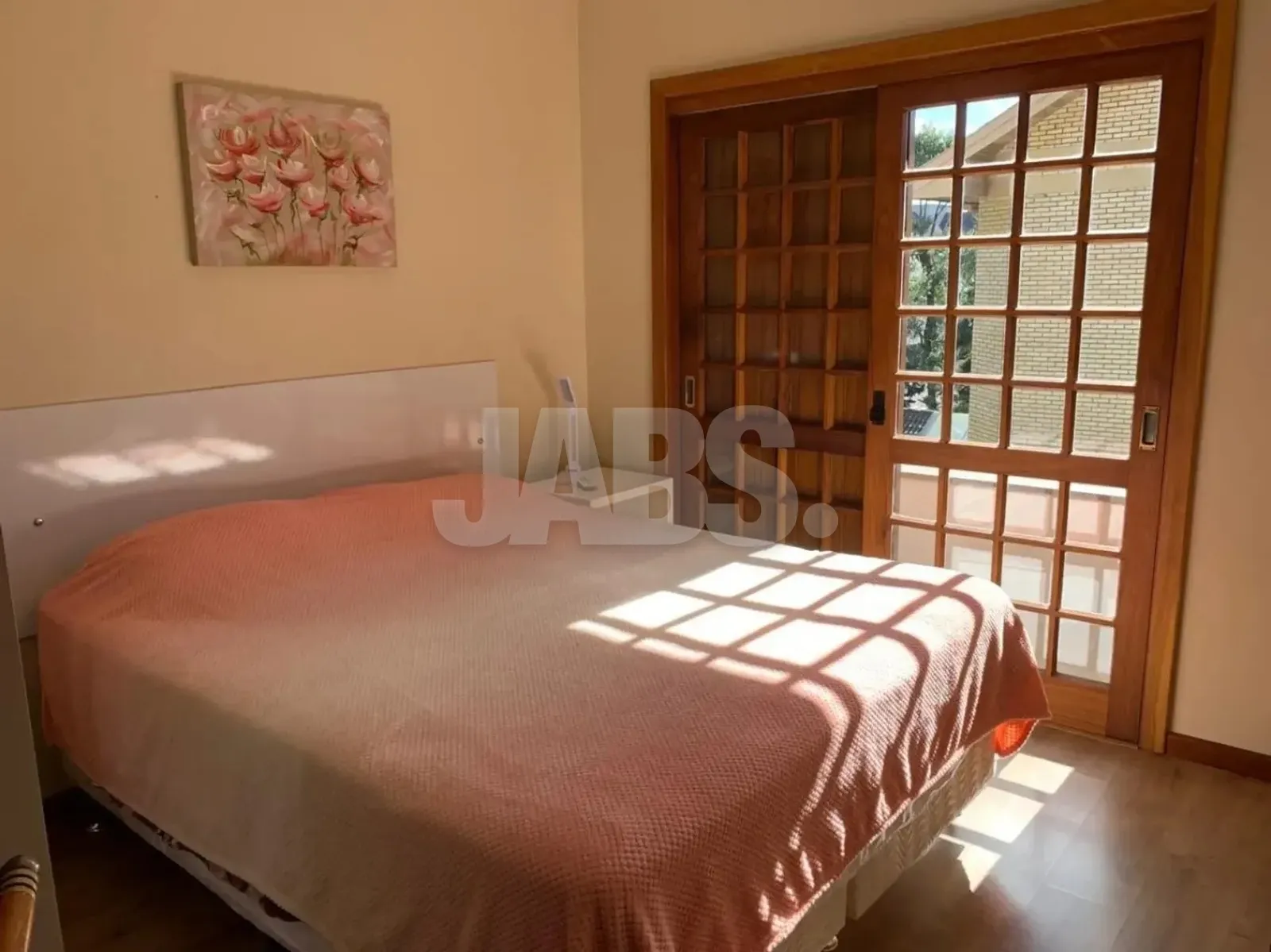 Dormitório de casal com porta de madeira para a sacada