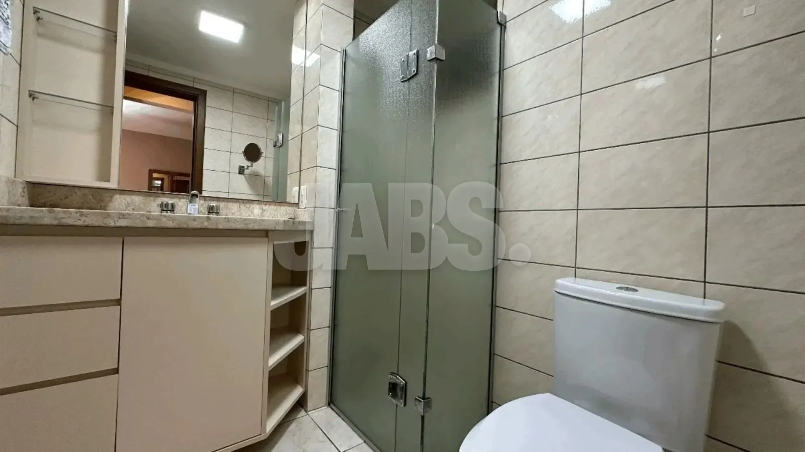 Banheiro com box de vidro e gabinete
