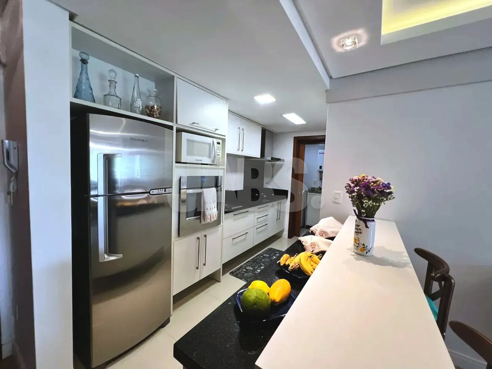 Cozinha com móveis planejados e geladeira inox
