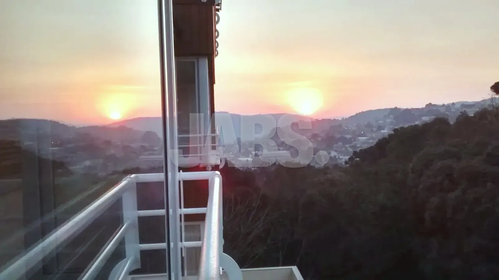 Pôr do sol sobre os morros visto da janela
