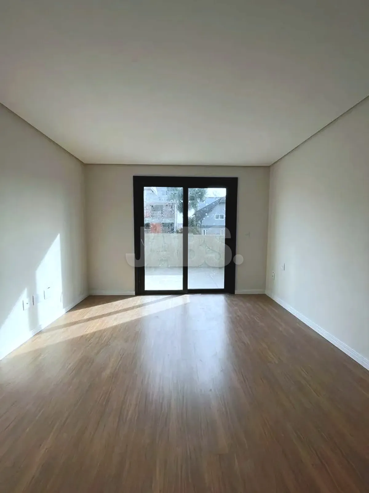 Sala ampla com porta de vidro para o terraço