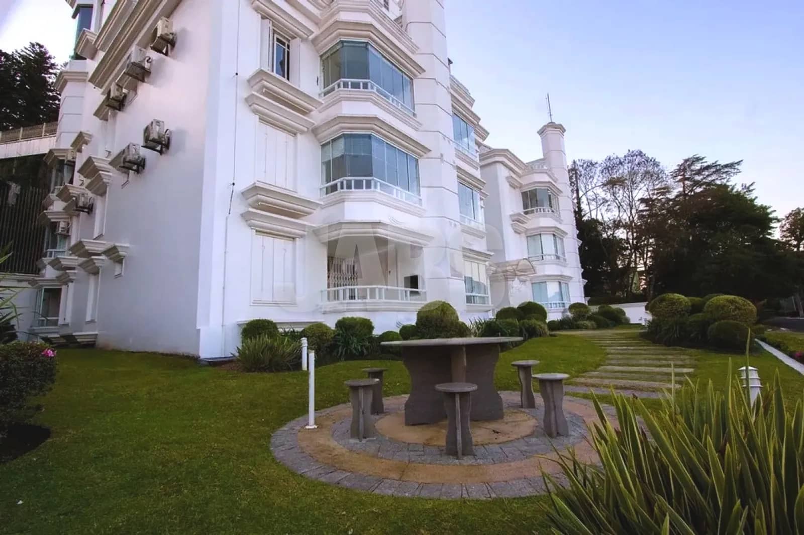 Jardim do prédio com mesa de pedra