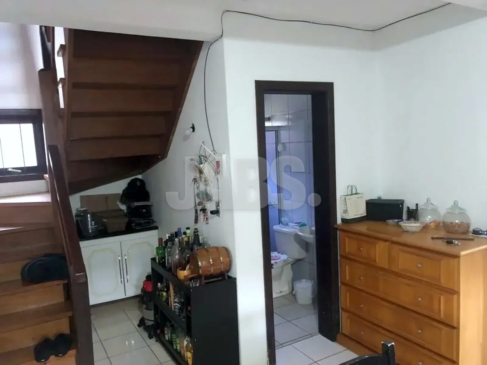 Hall sob a escada de madeira com acesso ao banheiro