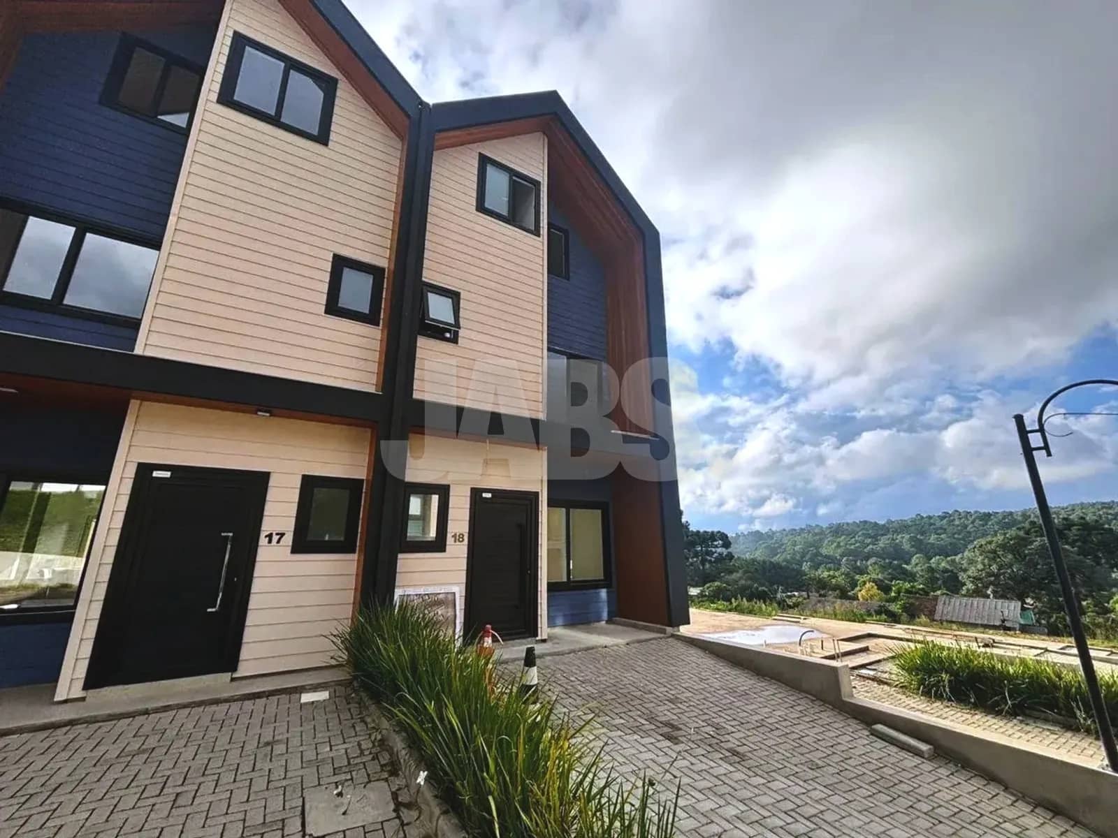 Fachada da casa em steel frame com revestimento claro e madeira