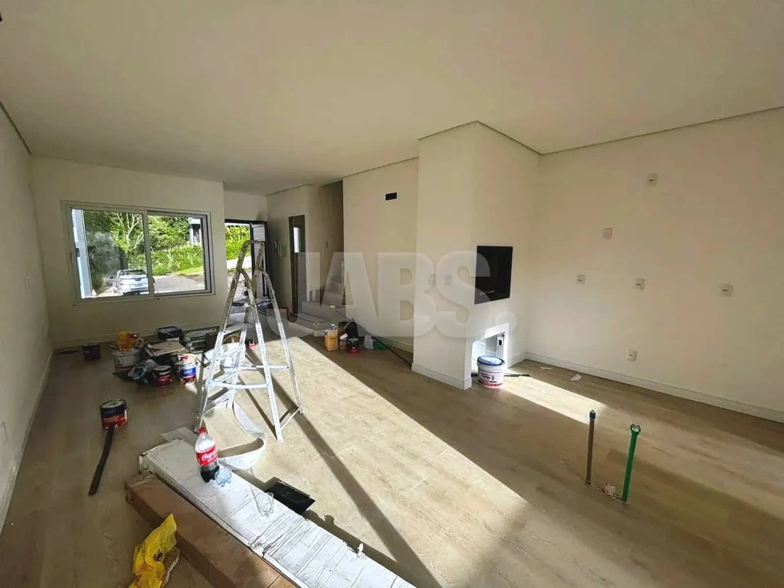 Sala com espera para lareira e janela para o jardim