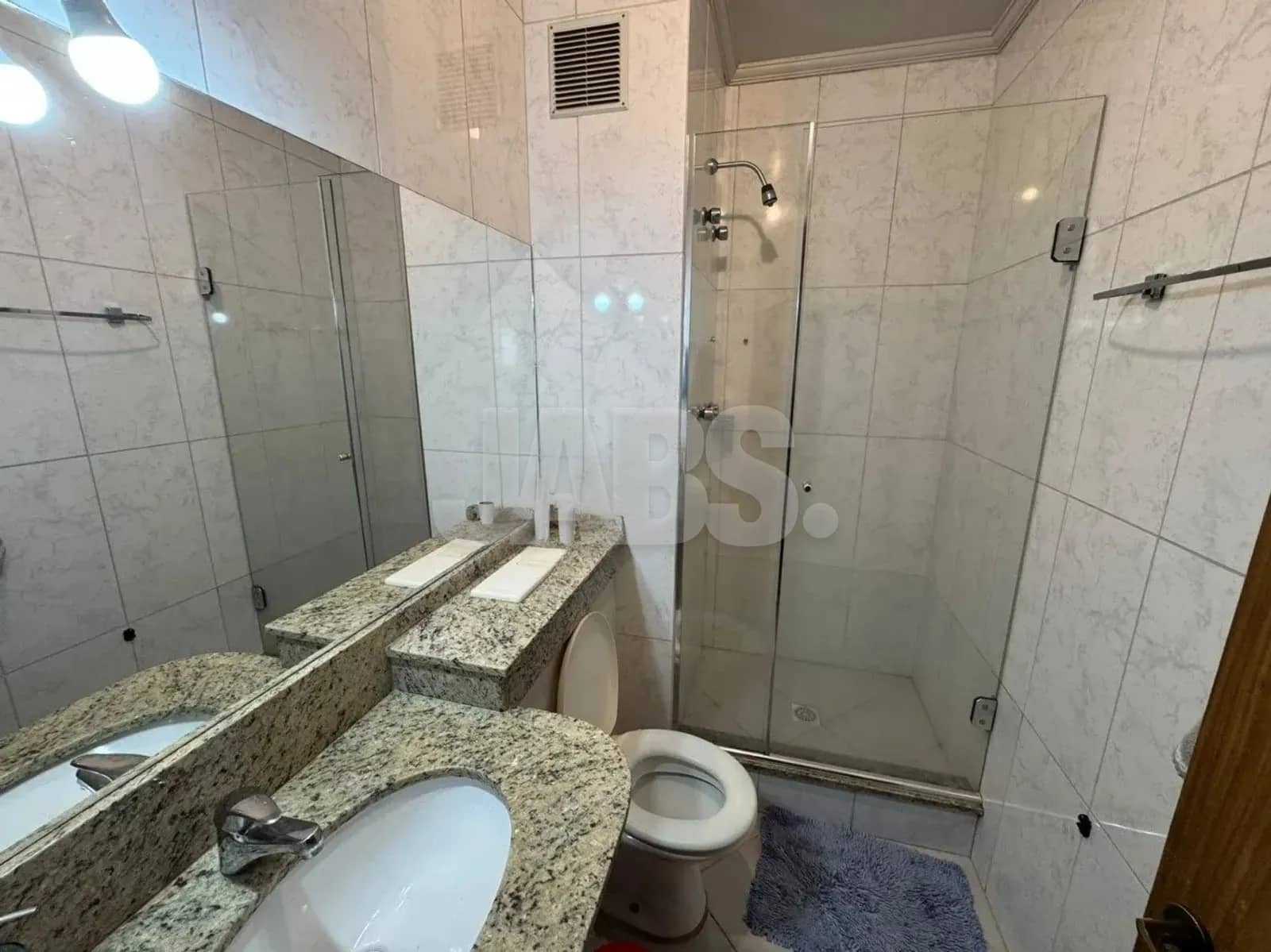 Banheiro com bancada de granito e box de vidro