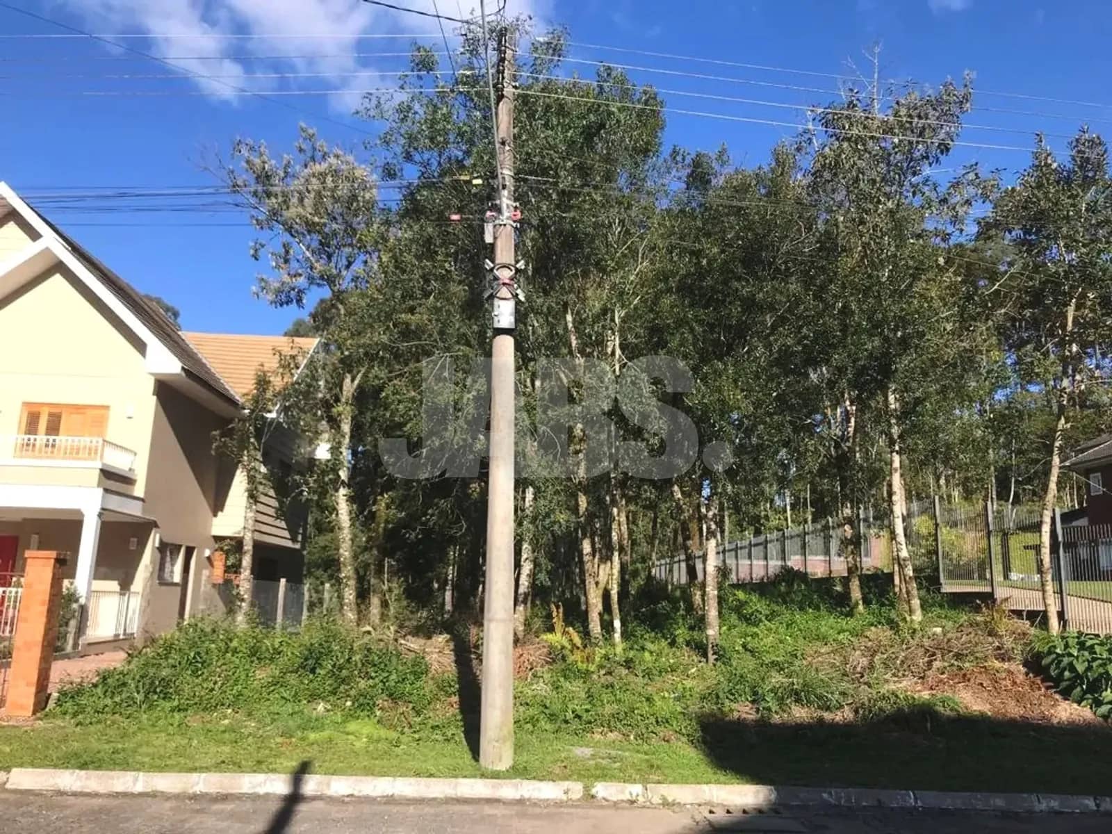 Terreno com árvores e poste na frente