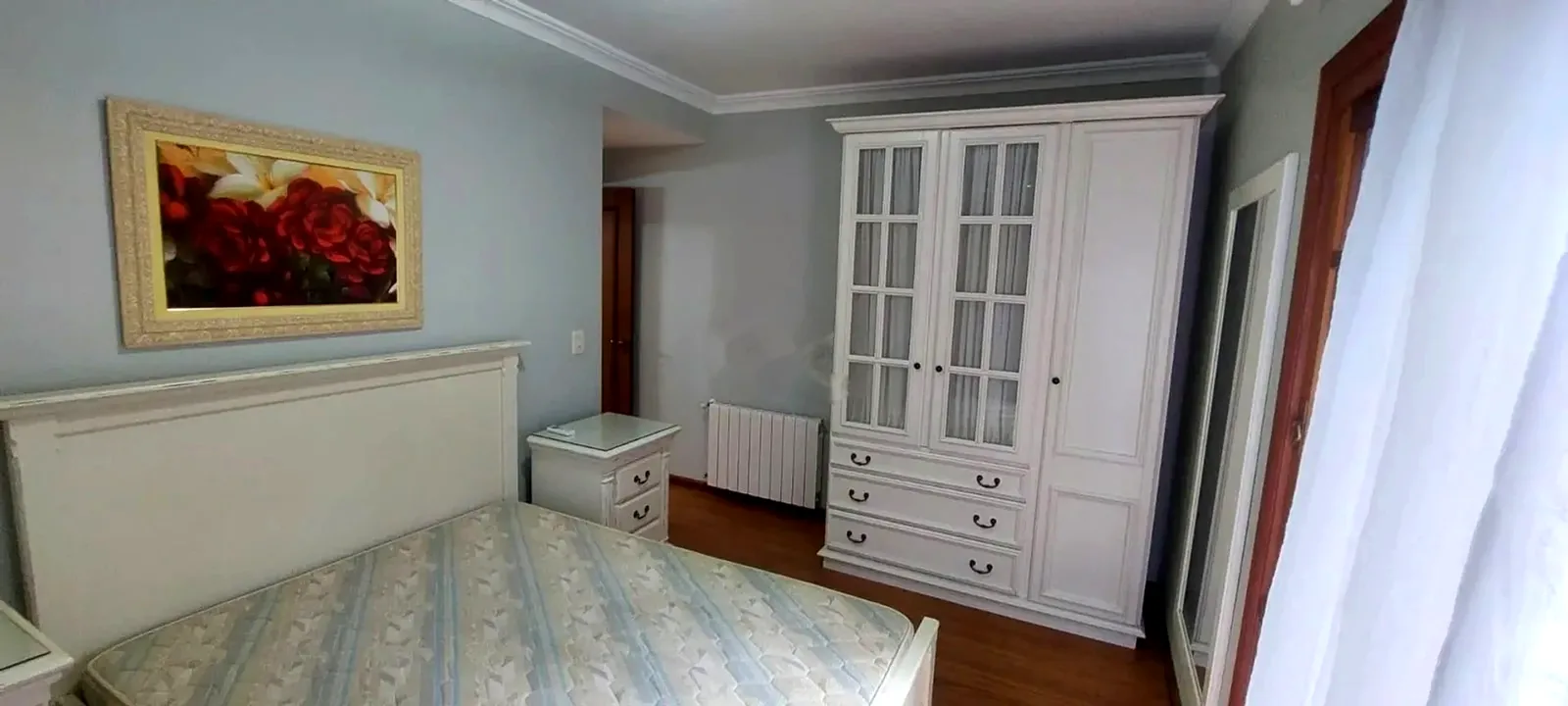 Dormitório com guarda-roupa branco e calefação
