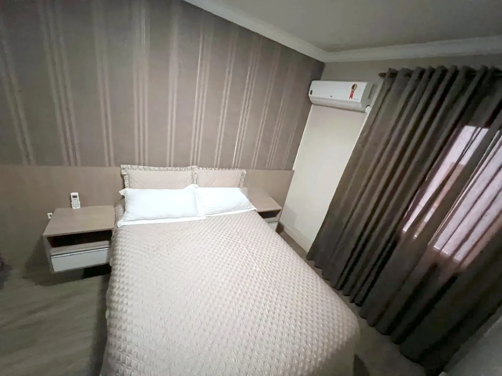 Dormitório com cama de casal e ar-condicionado