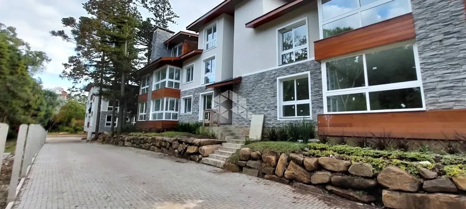 Prédio com janelas amplas entre o jardim