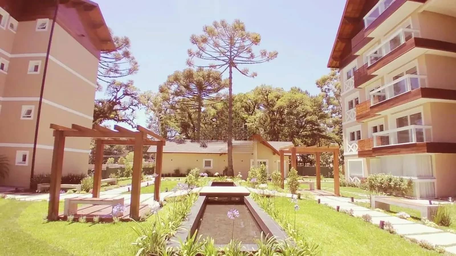 Jardim do condomínio com espelho d água e pergolados