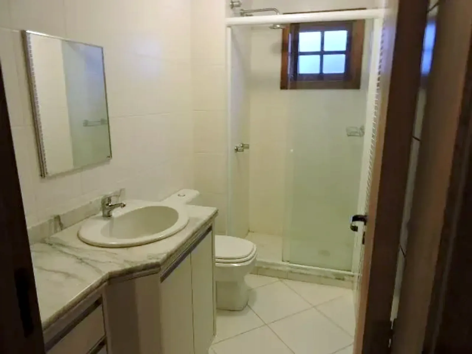 Banheiro com bancada de mármore e box