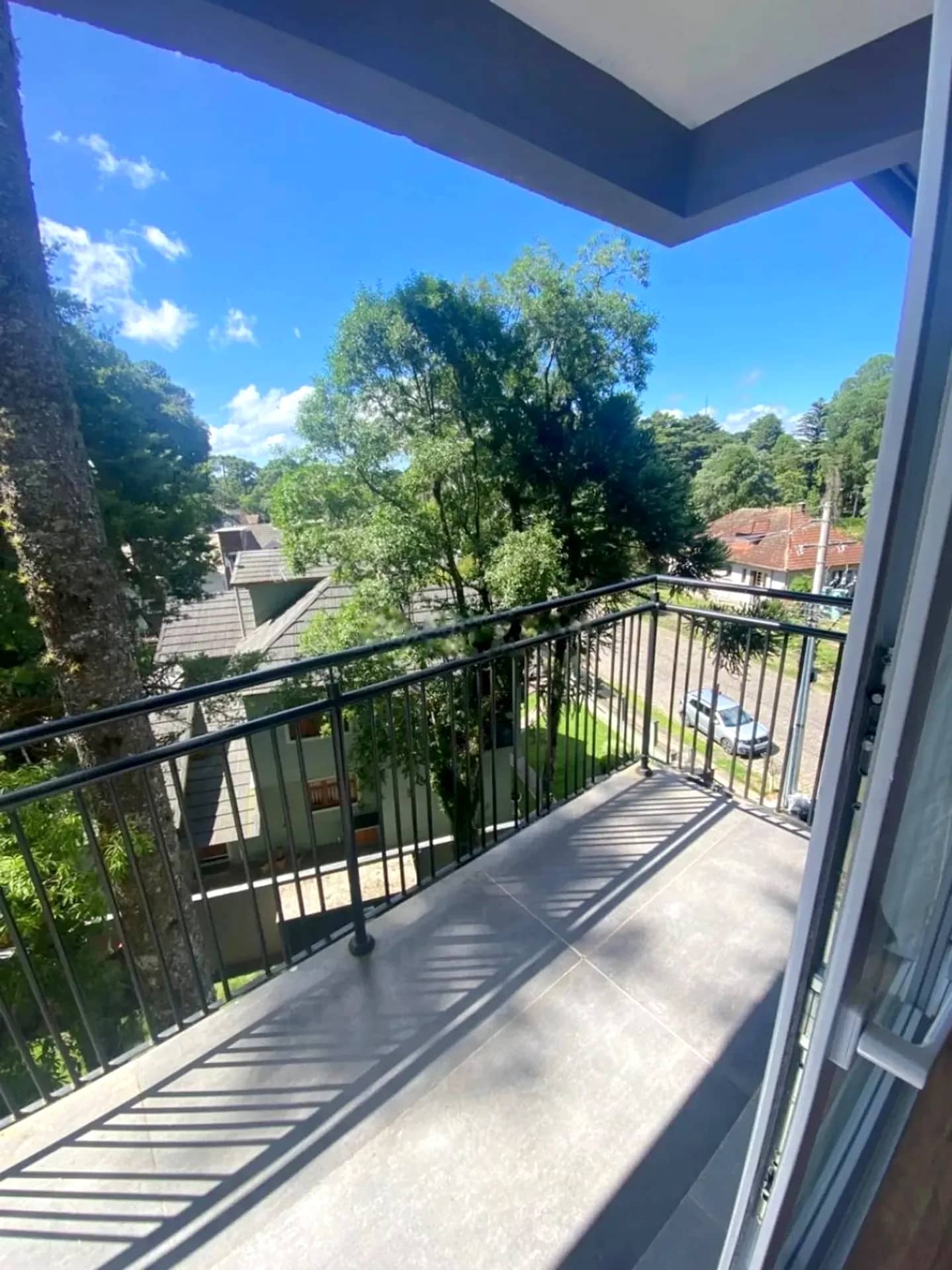 Sacada ampla com guarda-corpo e vista para o verde