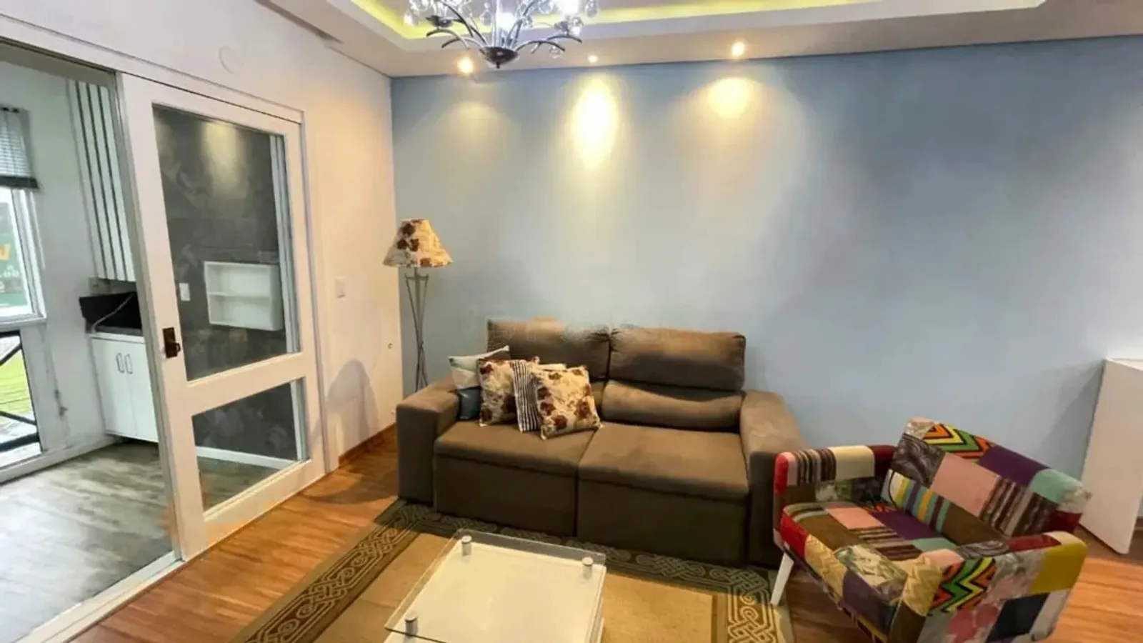 Sala de estar com sofá e porta para a sacada