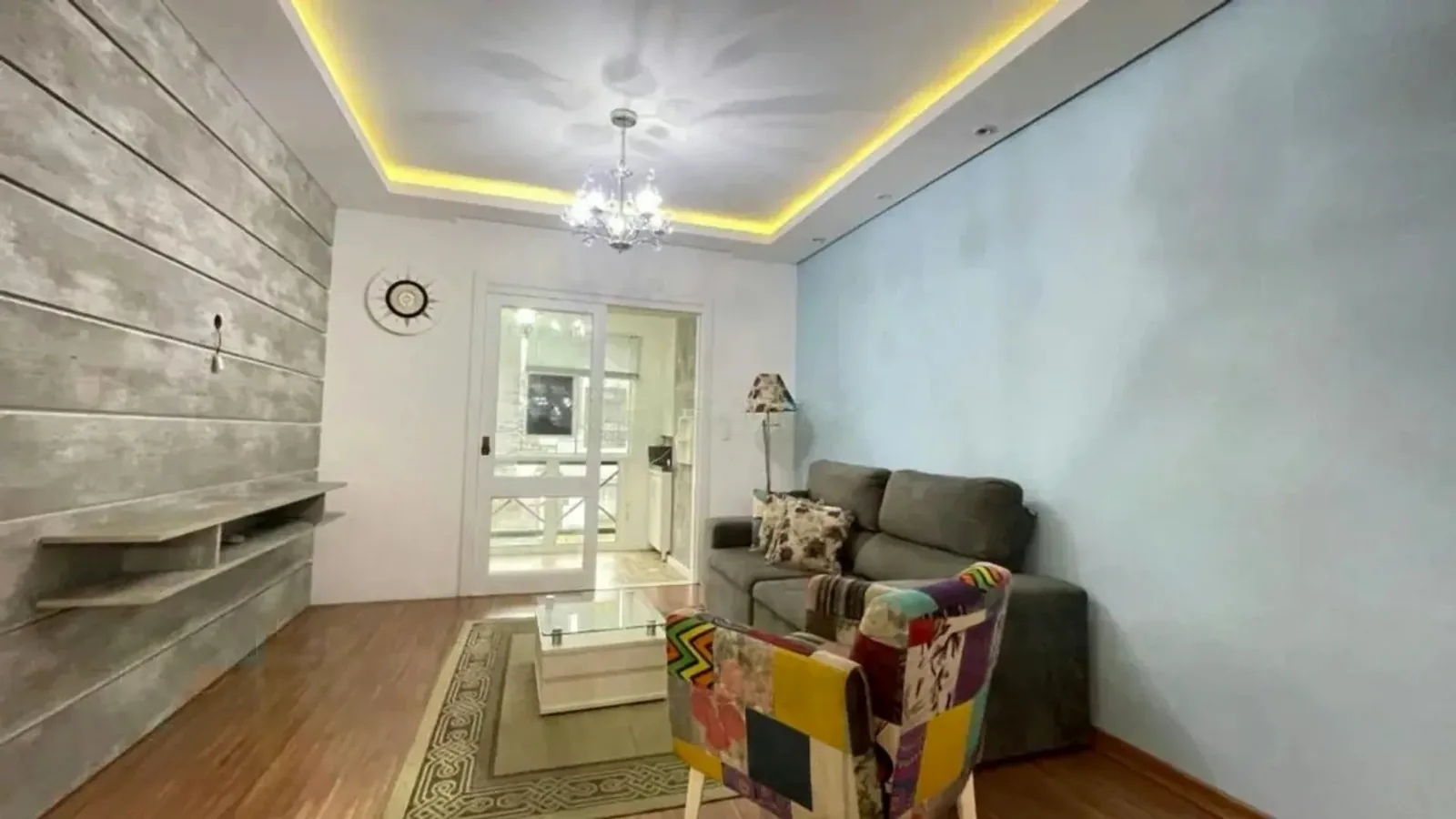 Sala com painel de madeira e acesso à sacada