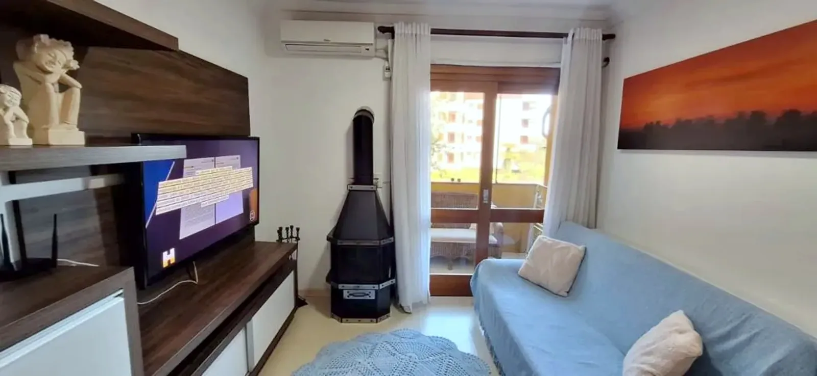 Living com lareira, TV e ar-condicionado