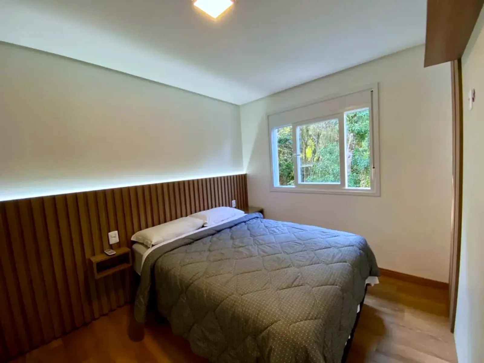 Suíte com painel de madeira