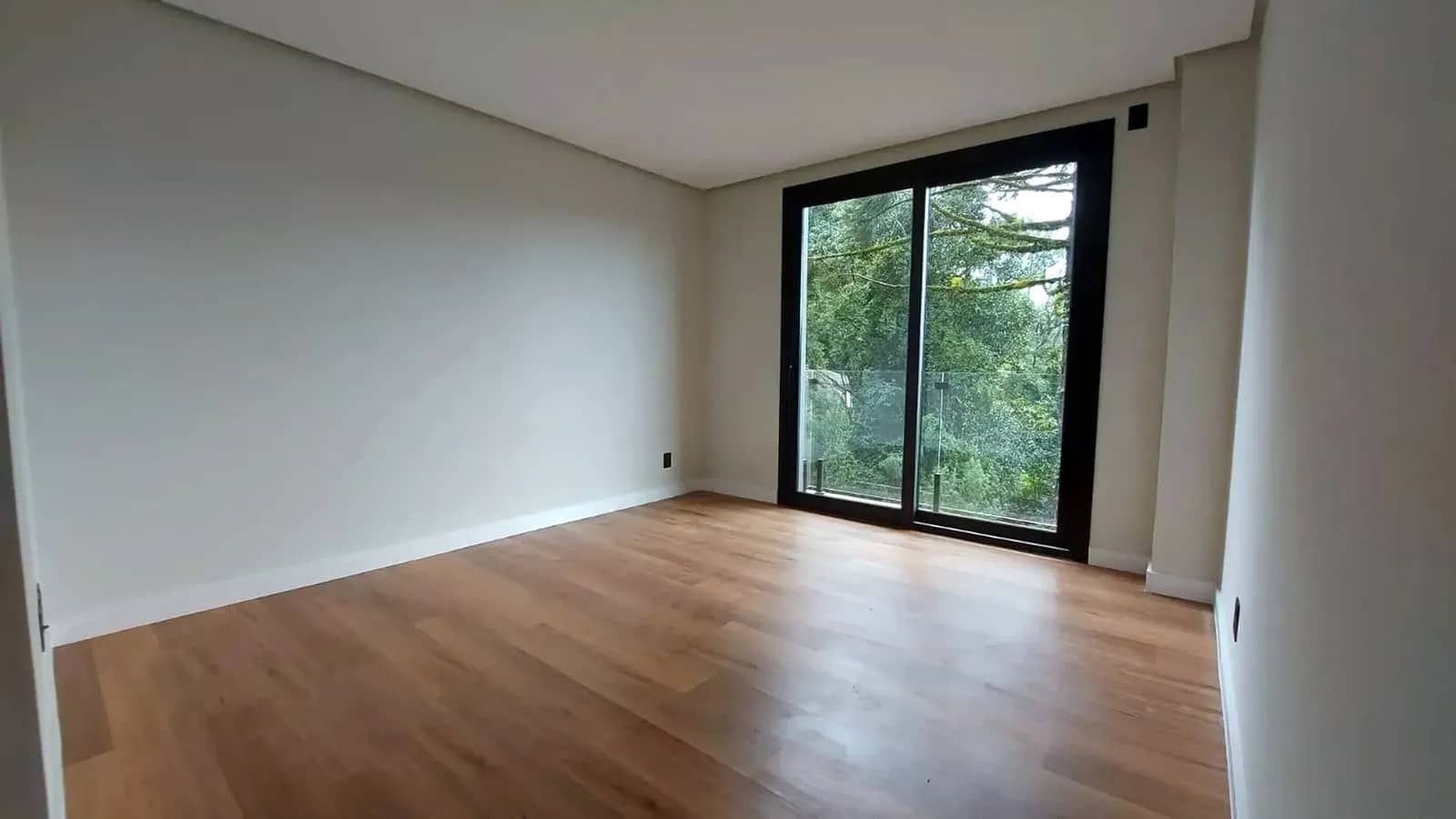 Living com janela do piso ao teto para o verde