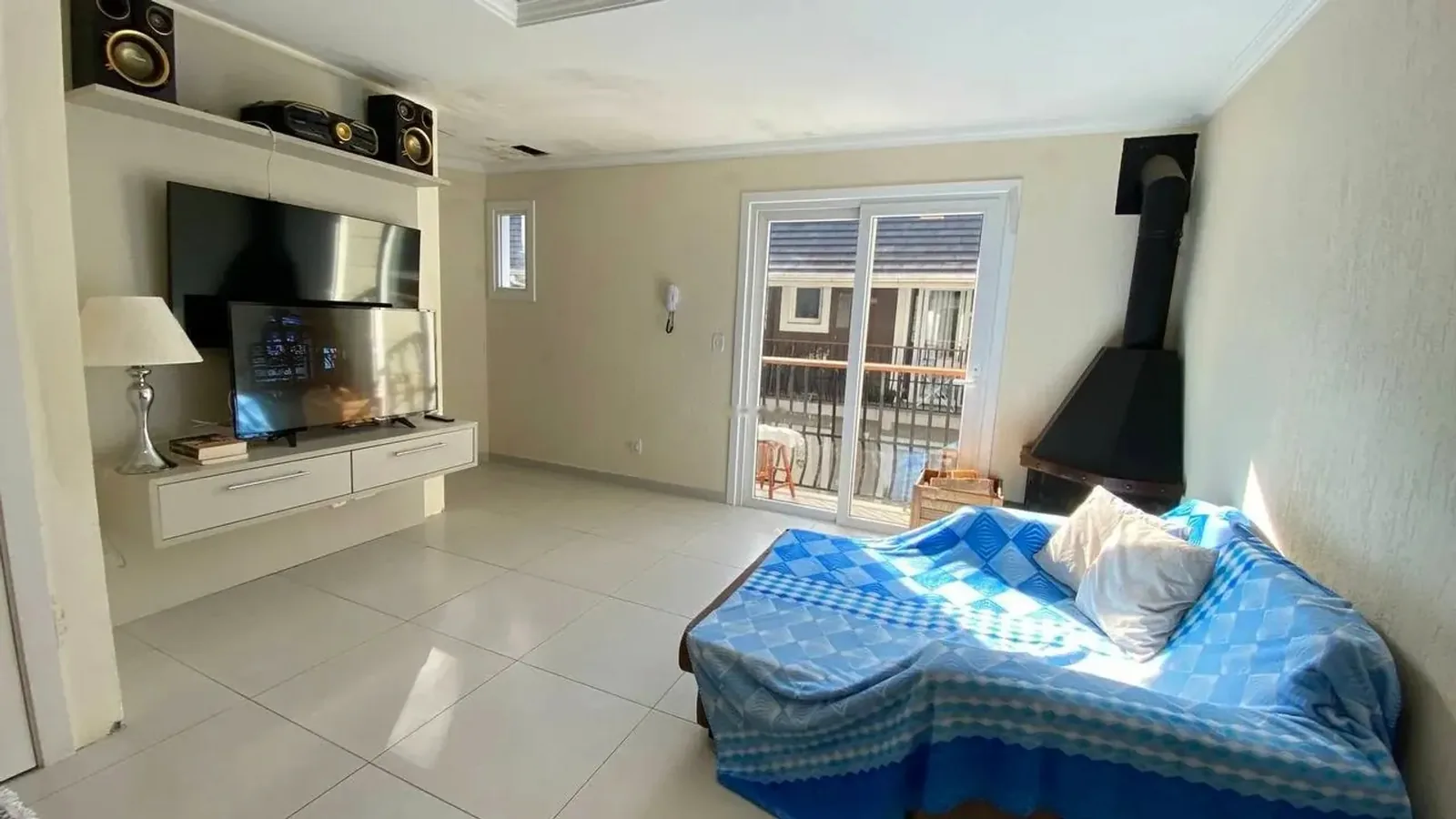 Living com lareira e porta para a sacada